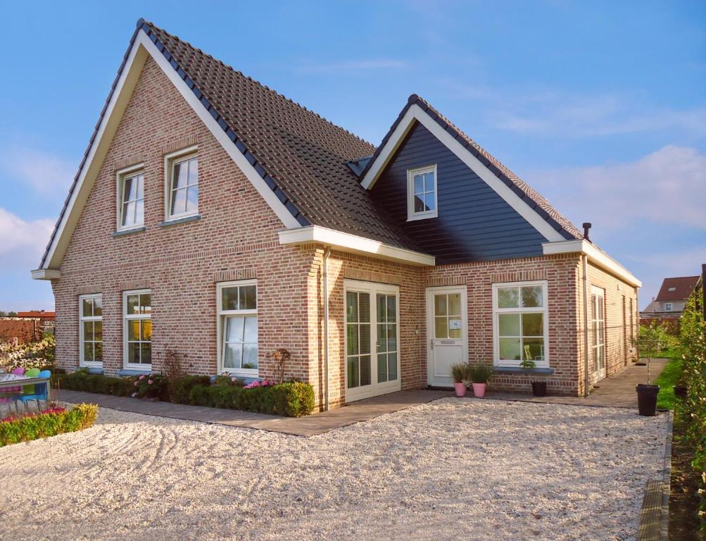 a red brick house with a black roof at Ferienhaus Zeeduinsepoort in Oostkapelle