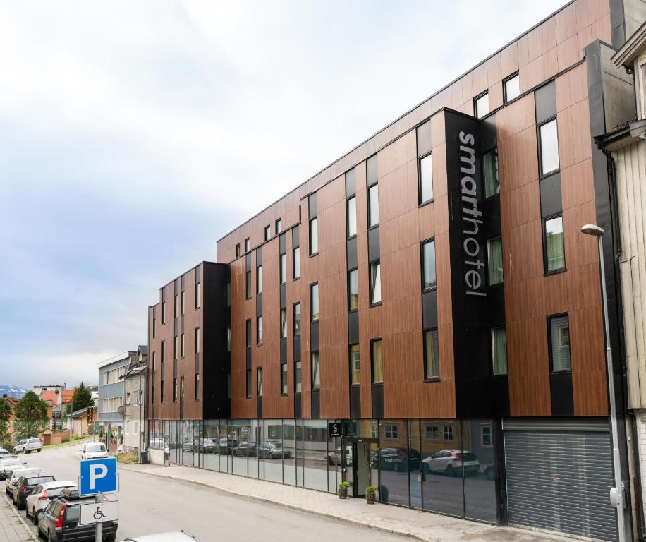 un bâtiment dans une rue avec un parking dans l'établissement Smarthotel Tromsø, à Tromsø