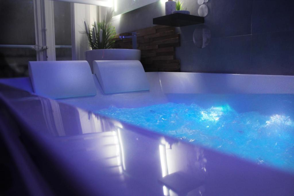 - une piscine d'eau bleue dans une pièce avec des chaises dans l'établissement Wonderlove cocon (coeur de ville, cathédrale), à Nantes