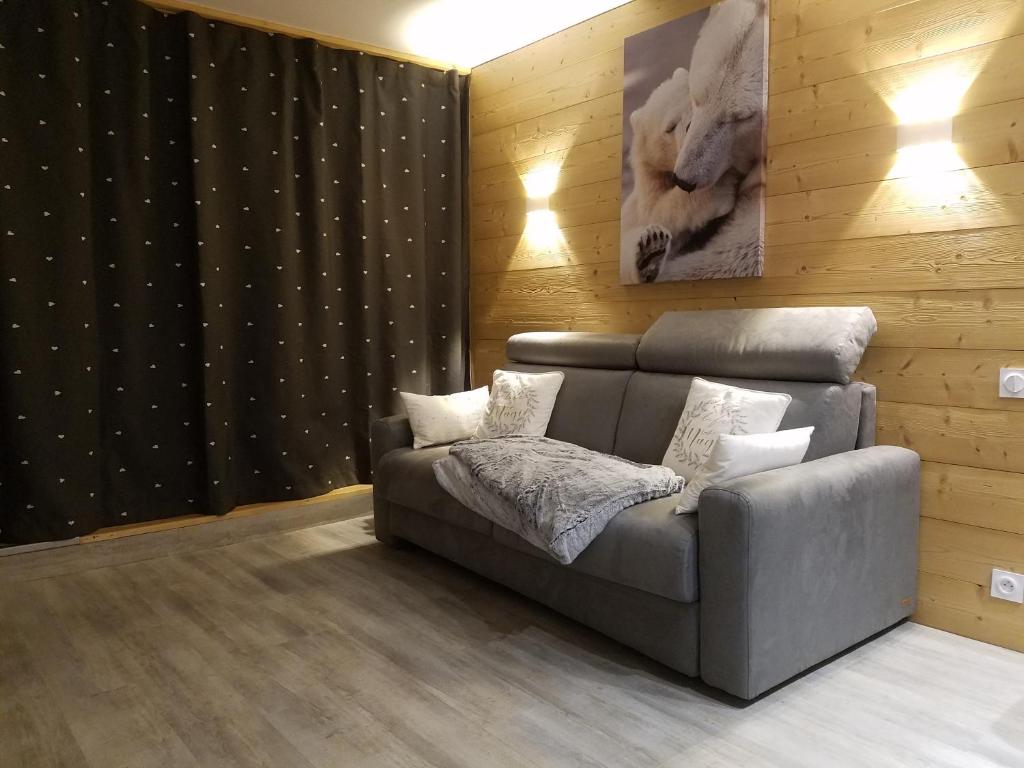 uma sala de estar com um sofá e uma fotografia de um urso em ARC 1800, Residence Pierra Menta em Arc 1800