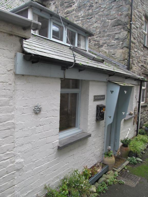 a white brick house with a window and a door at Bwthyn Bach Fishermans Cottage in Barmouth