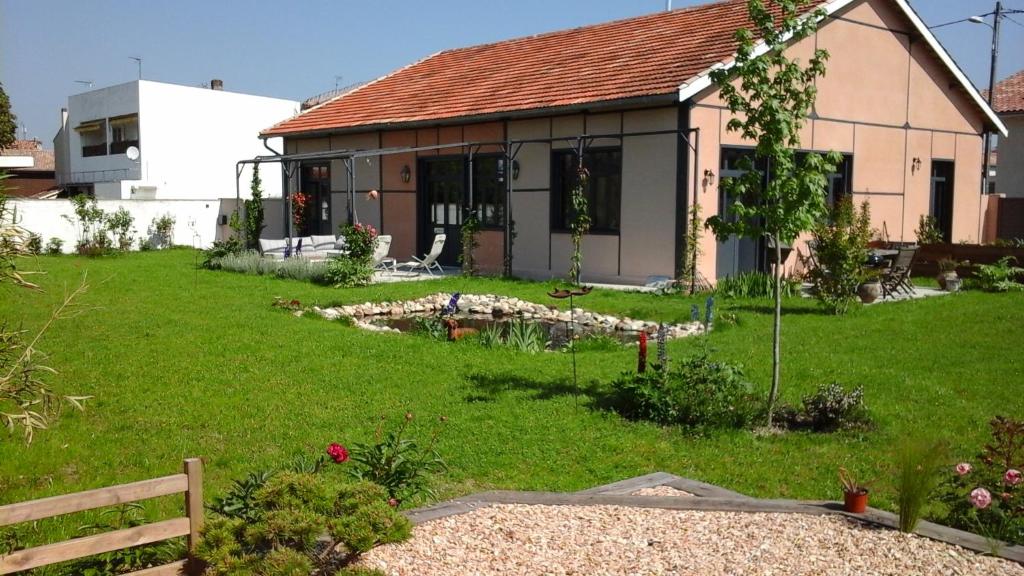 dom z zielonym ogródkiem przed nim w obiekcie L atelier w mieście Casteljaloux