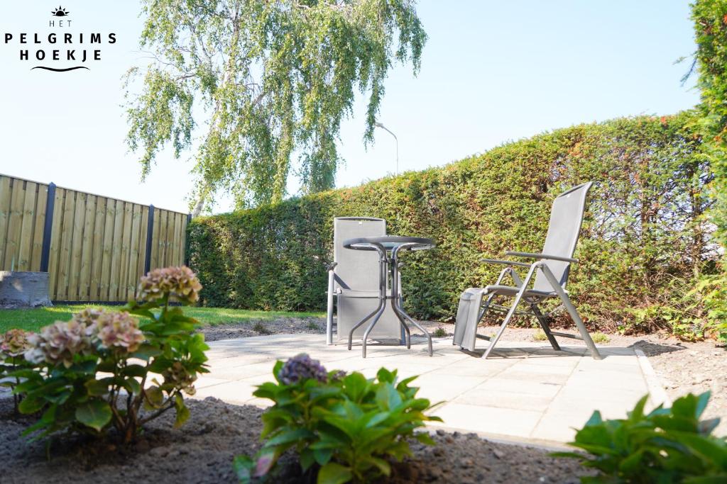 een patio met 2 stoelen en een tafel bij Het Pelgrimshoekje in Vrouwenpolder