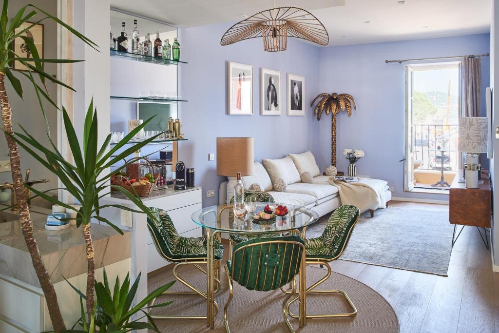 un soggiorno con tavolo e divano di Maison Panthère - Luxury Harbour Residence a Saint-Tropez