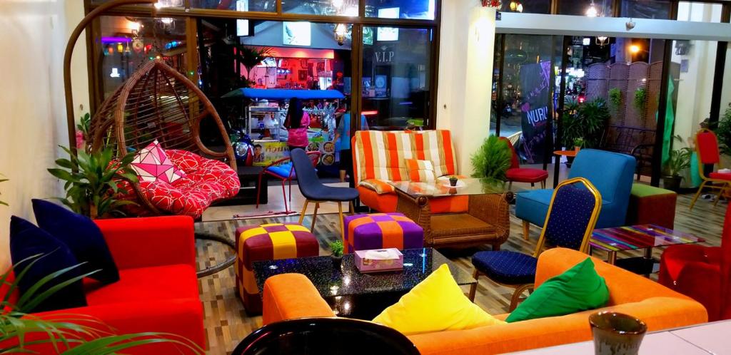 una habitación con sillas y mesas coloridas en una tienda en KANPAI HOTEL en Patong