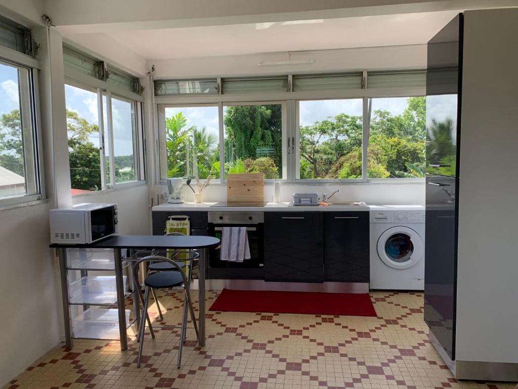 a kitchen with a sink and a washing machine at Soleil levant in Petit-Bourg