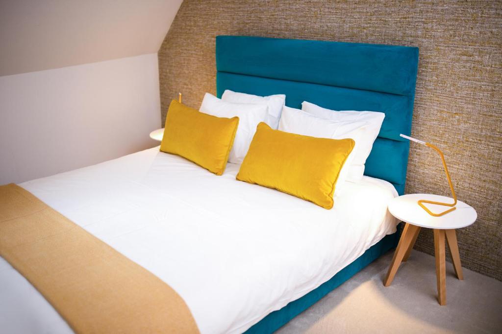 コパオニクにあるNeva Apartment Angella Konaciのベッドルーム1室(大型ベッド1台、黄色い枕付)