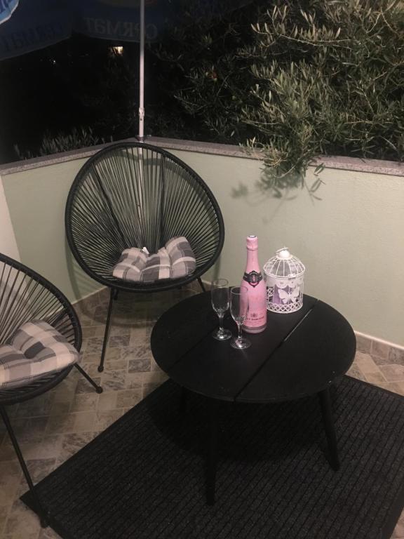 a table with two chairs and a pink bottle and glasses at Trebinje Mirjana in Trebinje