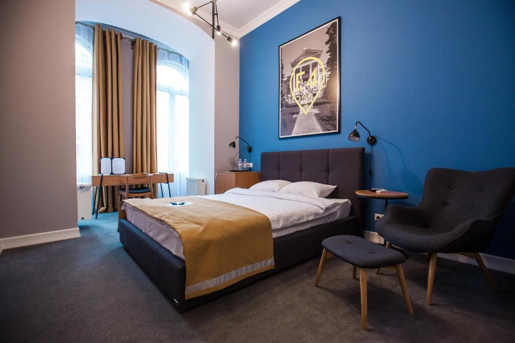 1 dormitorio azul con 1 cama y 1 silla en E4 Hotel, en Odessa