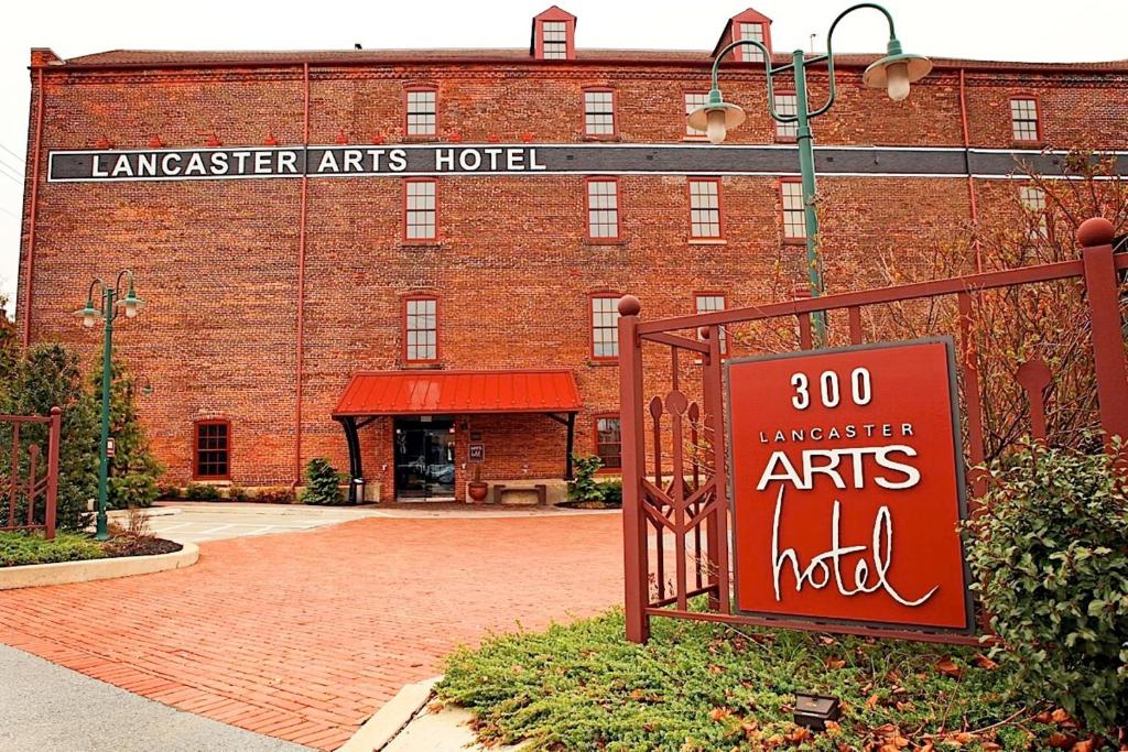 a large brick building with a sign in front of it at Lancaster Arts Hotel in Lancaster