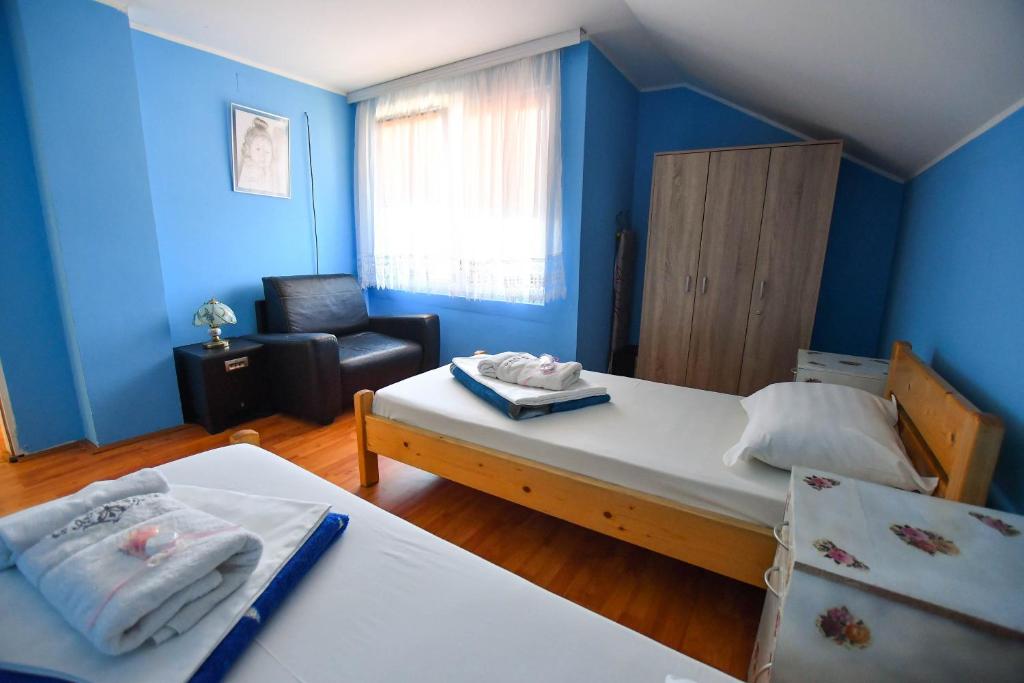 a small room with two beds and a chair at Nana Tekija in Tekija
