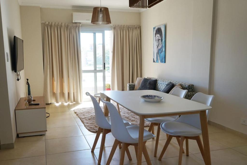a dining room table and chairs in a living room at Departamento amplio, nuevo y céntrico in Posadas