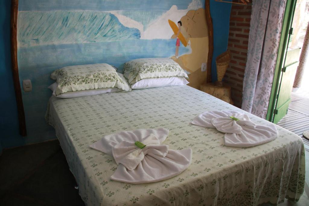 - une chambre avec un lit et des serviettes dans l'établissement Maria Teresa Bragança Pousada, à Jericoacoara