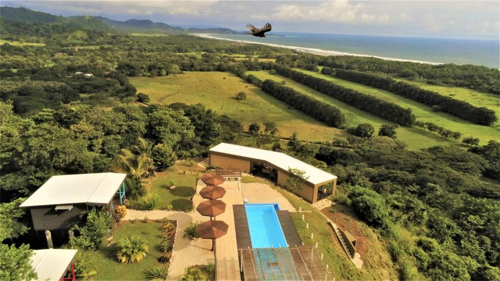 un avión sobrevolando una casa con piscina en La Colina Pura Vista, en Bejuco