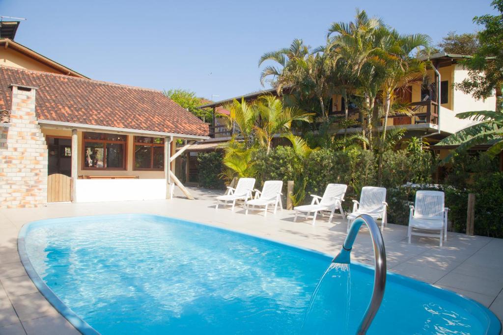 una piscina con sillas y una casa en Morada do Gabriel, en Guarda do Embaú