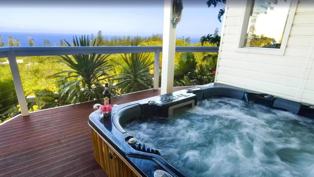 a hot tub on the deck of a house at Cumberland Resort & Spa in Burnt Pine