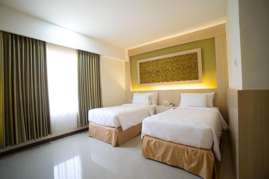 Postel nebo postele na pokoji v ubytování Luminor Hotel Banyuwangi By WH