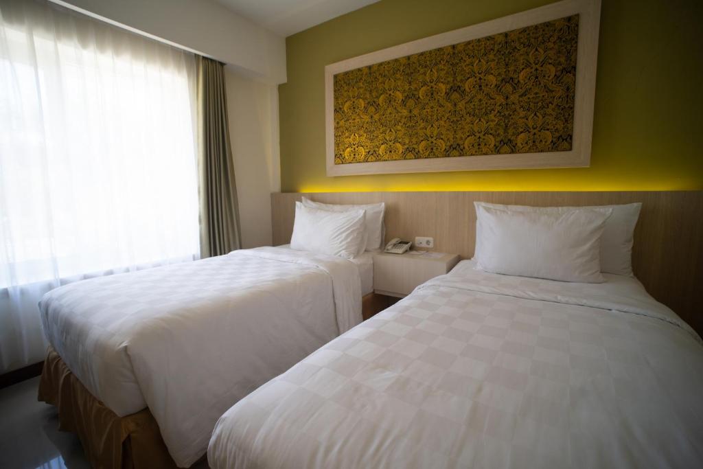Postel nebo postele na pokoji v ubytování Luminor Hotel Banyuwangi By WH