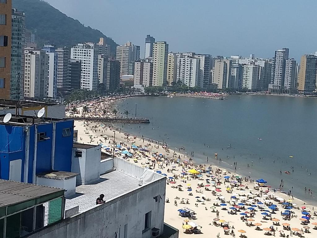 einen überfüllten Strand mit Sonnenschirmen und Menschenmengen in der Unterkunft Edifício Lord - APTO in São Vicente