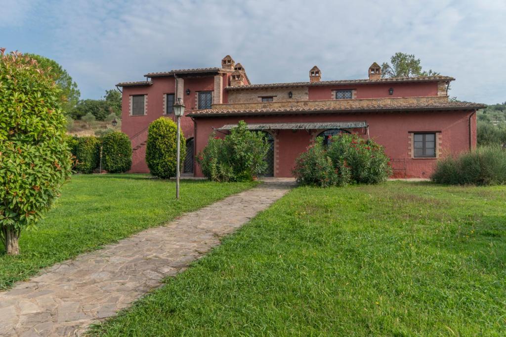 una gran casa roja con un patio de césped en Agriturismo Le Case Rosse di Montebuono, en Magione
