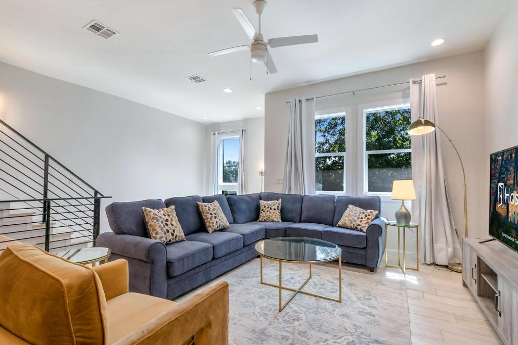 uma sala de estar com um sofá azul e uma televisão em Beautiful Townhouse in a Gated Community em Nova Orleans