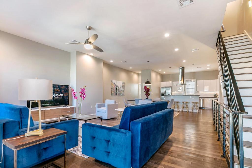 a living room with blue furniture and a kitchen at New Construction Elegant Villas in New Orleans