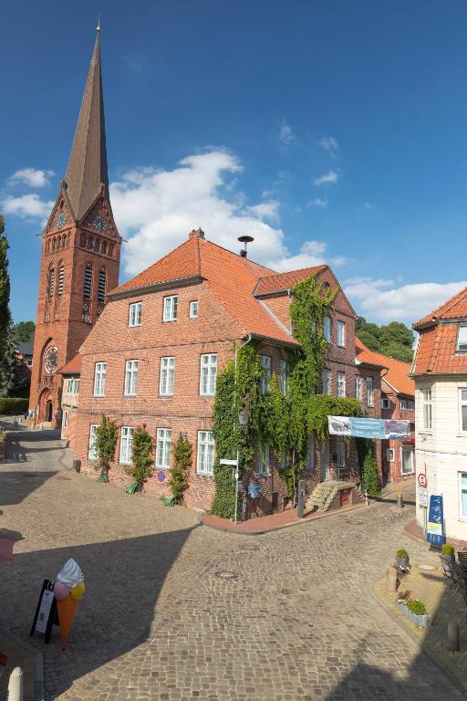 a large brick building with a church with a tower at Gästehaus Von Herzen in Lauenburg