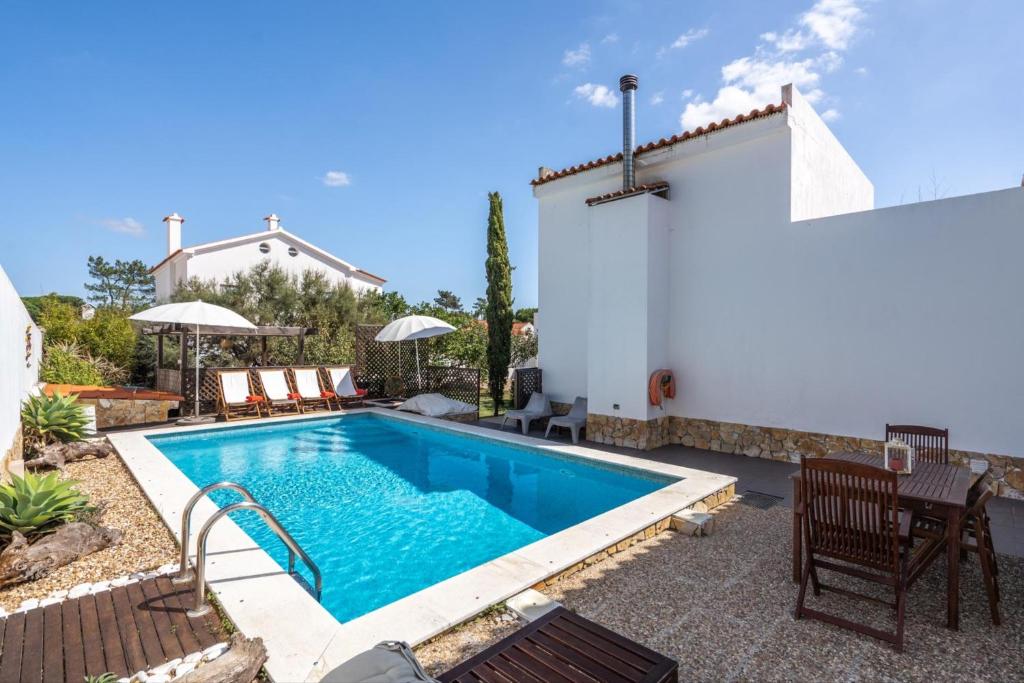 a swimming pool in the backyard of a house at Akivillas Sesimbra Ocean in Lagoa de Albufeira