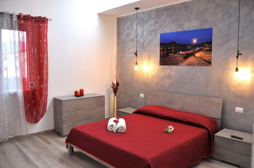 una camera con un letto rosso e una coperta rossa di R&B mediterraneo a Bosa