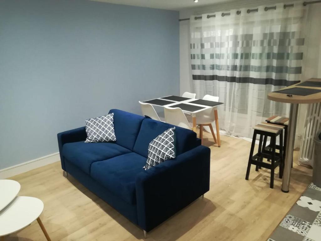un salon avec un canapé bleu et une table dans l'établissement La Crochardière centre ville Le Mans, au Mans