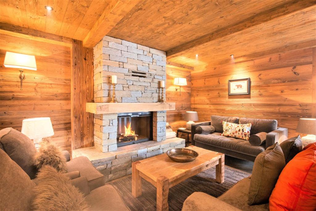 a living room with a fireplace in a log cabin at Chalet Ourson Brun by Mrs Miggins in Grimentz