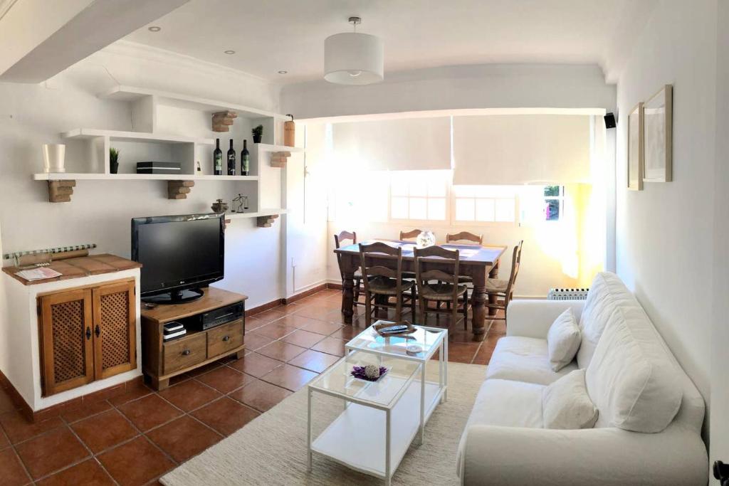 Piso en San Roque, centro neurálgico del Campo de Gibraltar في سان روكي: غرفة معيشة مع أريكة بيضاء وطاولة