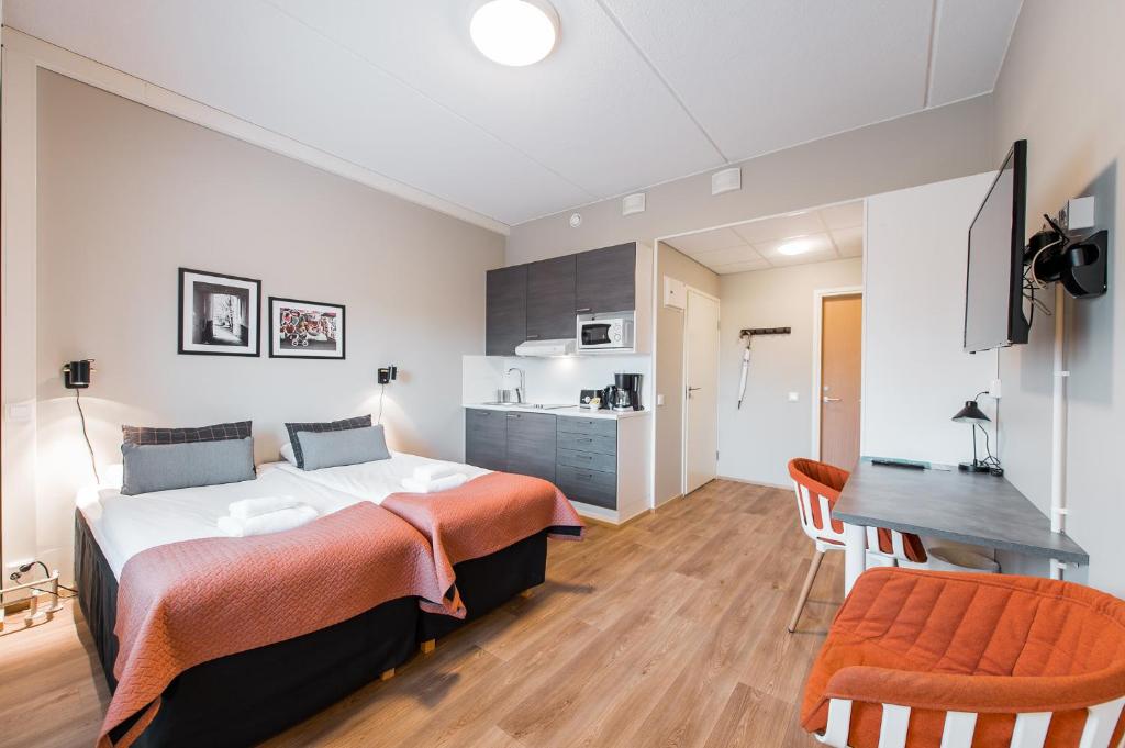 una camera con letto e scrivania e una cucina di Forenom Aparthotel Espoo Leppävaara a Espoo