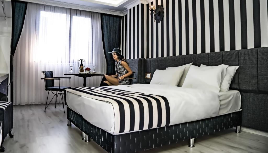 a woman in a hotel room with a large bed at Cnr İnci Hotel in Istanbul