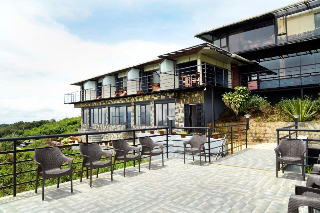 Casa con balcón y patio con sillas. en StayVista at Talerock Inn Mountain View - Breakfast Included, en Vālpārai