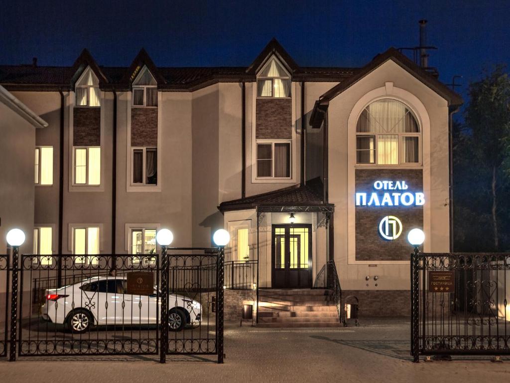 un coche blanco estacionado frente a un edificio en Hotel Platov na Dubovskogo, en Novocherkassk