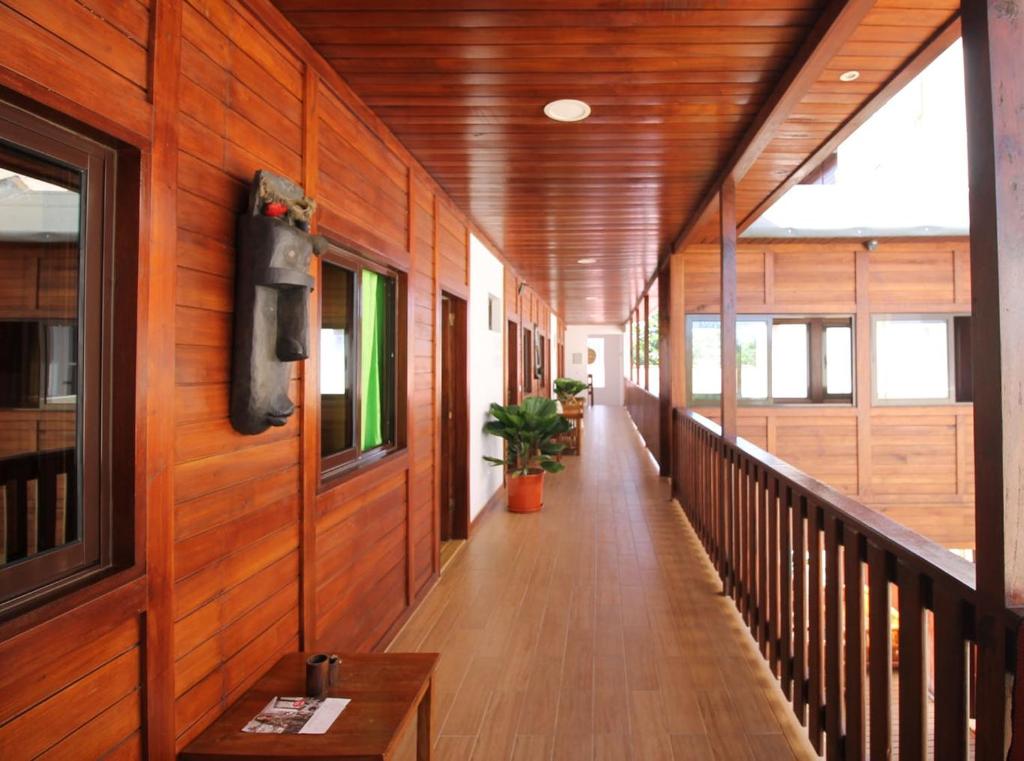 a hallway of a building with wood paneled walls and a hallway sidx sidx sidx at Sweet Guest House in São Tomé