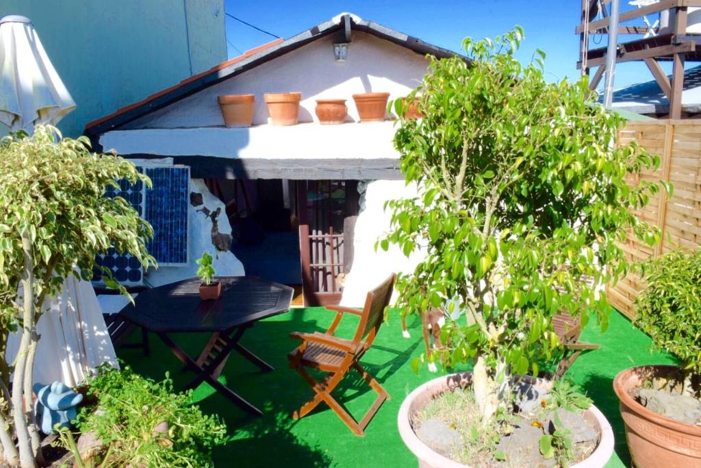 una pequeña casa con una mesa y sillas en un patio en Finca Casa Madera 1, en Icod de los Vinos