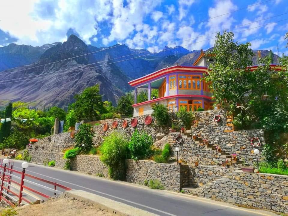 a house on a hill next to a road at Hikal Guest House in Hunza