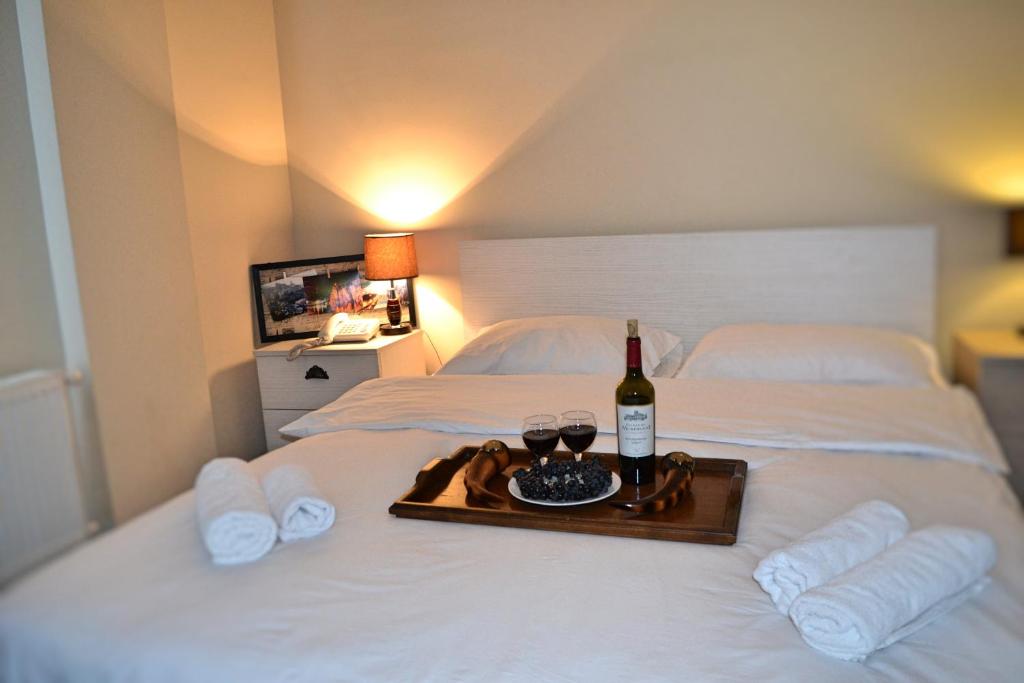a bed with a bottle of wine on top of it at City Center GNG in Tbilisi City