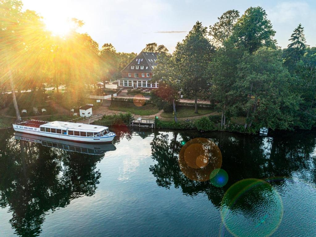 um barco num rio em frente a uma casa em Lake House Plön em Plön