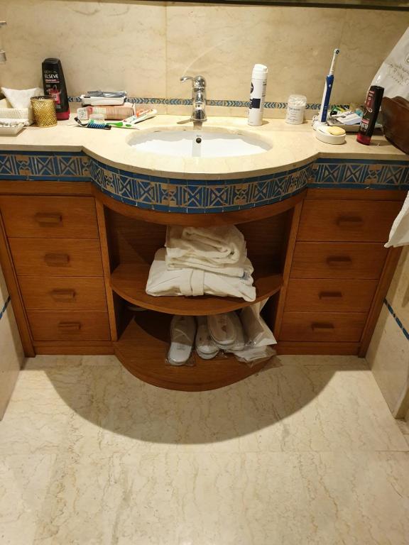 马拉喀什Jnane Gueliz的浴室设有水槽和一堆毛巾