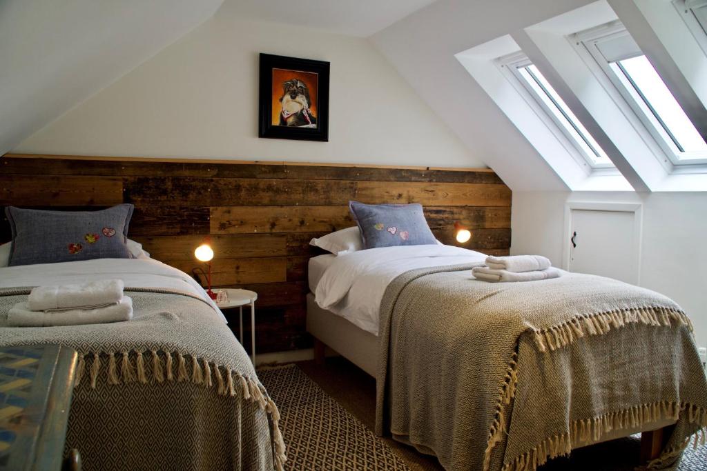 Duas camas num quarto com clarabóias em Orford Lodge Barn em Orford