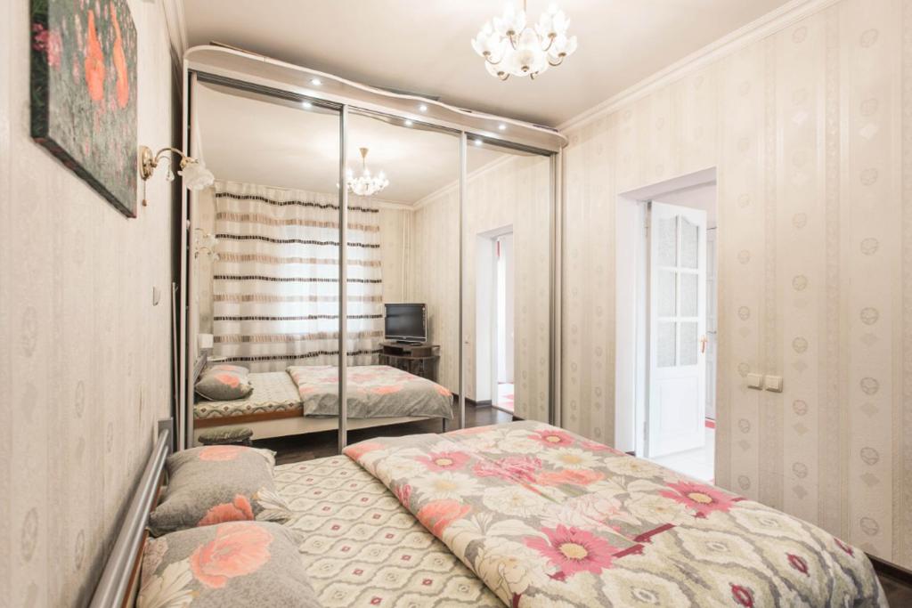 una camera da letto con due letti e uno specchio di Deribasovskay street apartments a Odessa