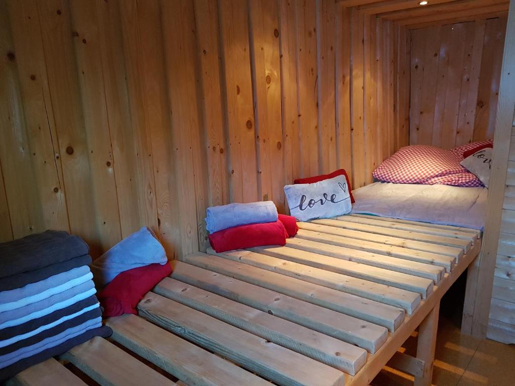 a wooden bed in a wooden cabin with pillows at Der Perweinhof in Donnersbachwald