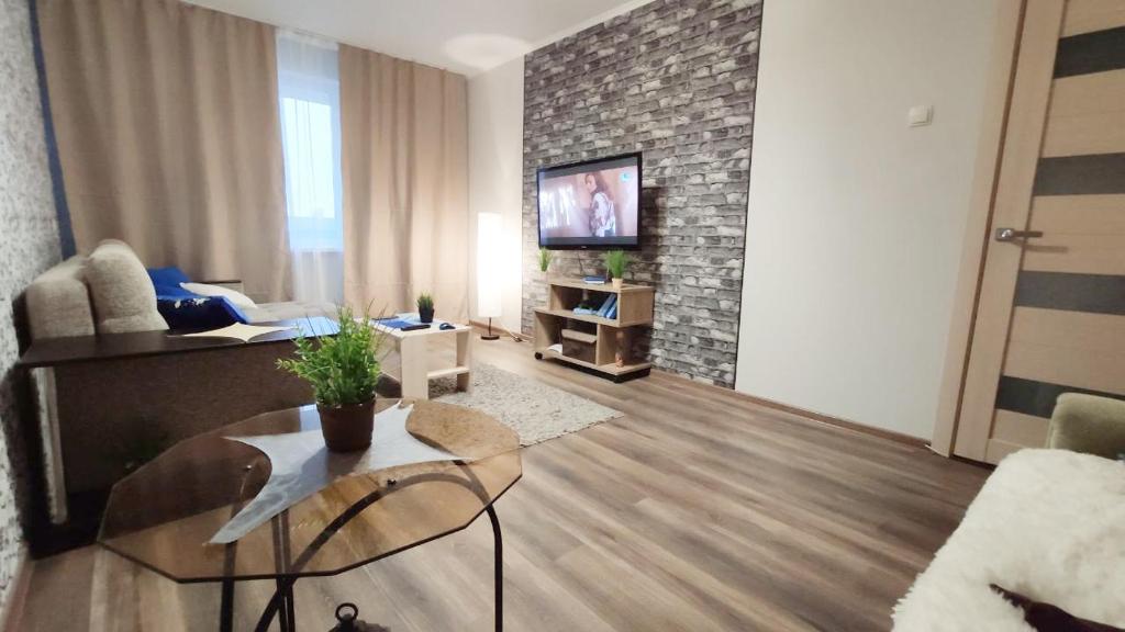 a living room with a couch and a tv at Good Apartments in Gomel