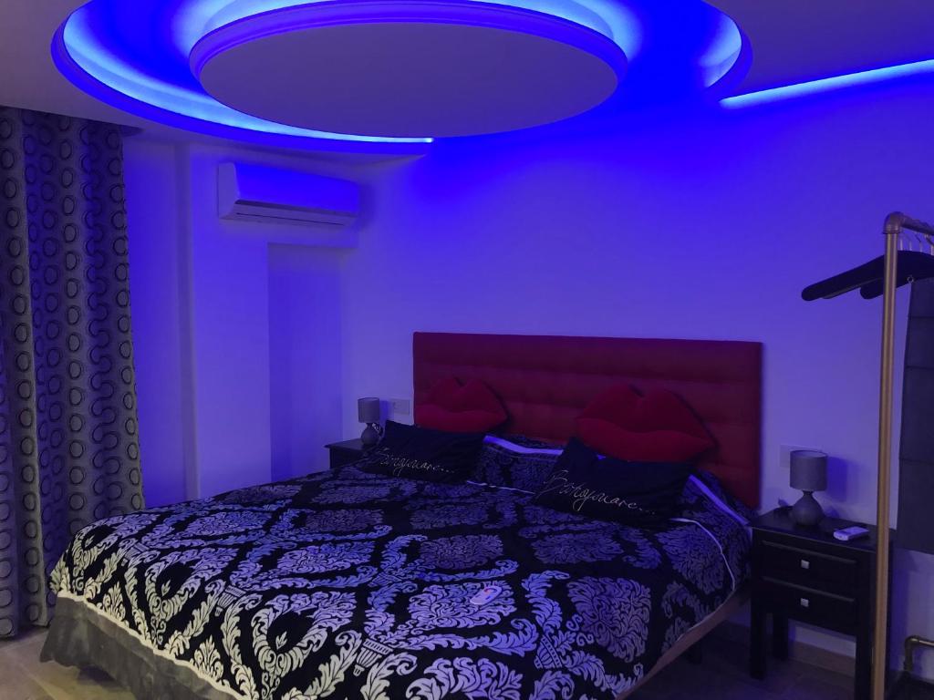 Fioletowa sypialnia z łóżkiem i niebieskim sufitem w obiekcie Loft romántico w mieście Algeciras