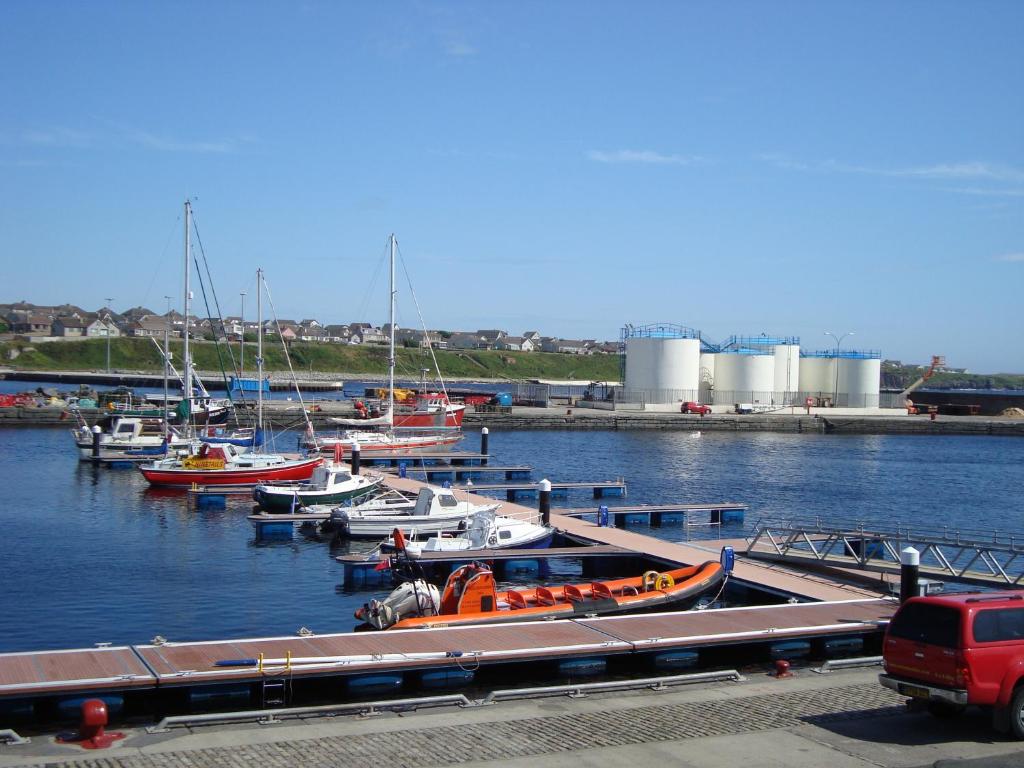 een groep boten aangemeerd in een haven bij Harbour View Apartment Wick in Wick