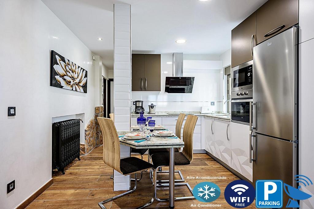 Hotel Salamanca Frog, a kitchen with a table with chairs and a refrigerator at Salamanca Frog in Salamanca