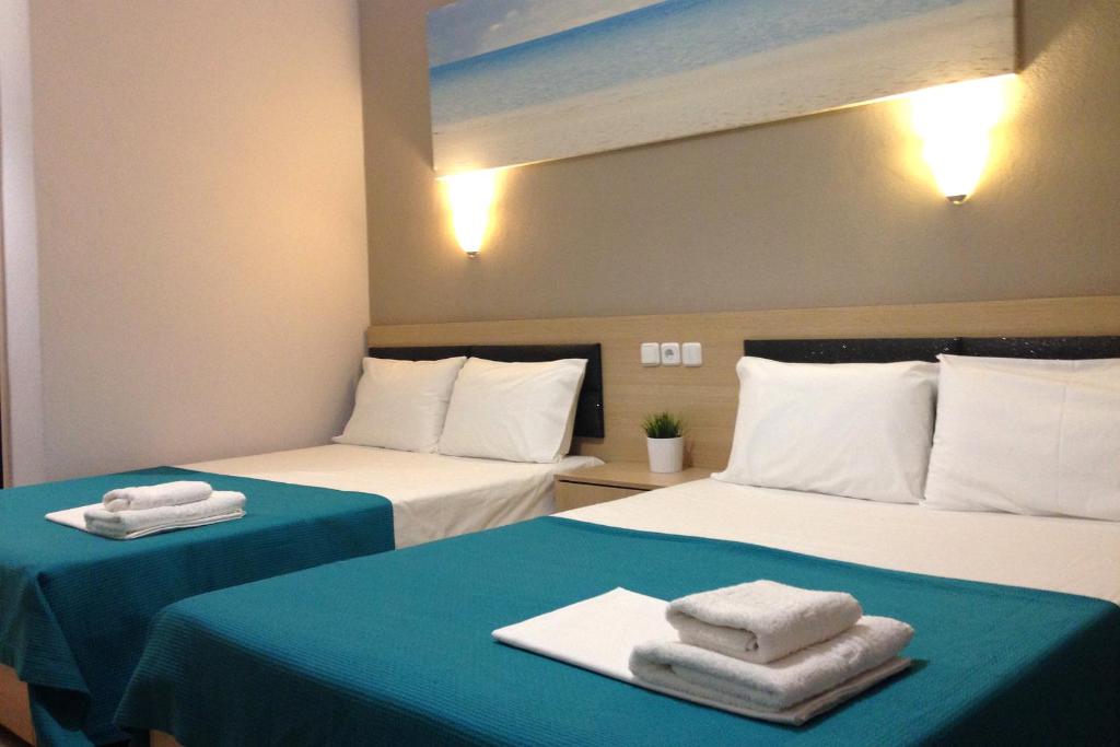 two beds in a room with towels on them at Ocean Breeze Apartment Colombo in Colombo